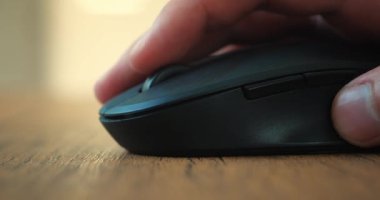 Yakın plan. Bir adam bilgisayar faresine tıklıyor ve bilgisayar başında çalışırken silindir kullanıyor. İnternet 'te bilgi aranıyor