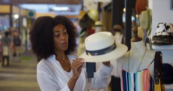 Χαρούμενη Αφρο Αμερικανίδα Που Δοκιμάζει Ένα Χαριτωμένο Ψάθινο Καπέλο Ενώ — Αρχείο Βίντεο