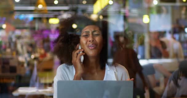 Afroamerykanka Zmartwiona Kobieta Rozmawiająca Przez Telefon Komórkowy Siedząca Przy Laptopie — Wideo stockowe