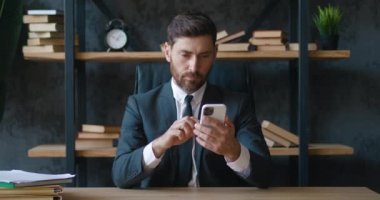Ofiste otururken akıllı telefondan kötü haberler okuyan sinirli bir girişimci. İş yerinde duygusal stres yaşayan kötü mesajcı girişimci tarafından şok edildi. Konsepti kaybetmek
