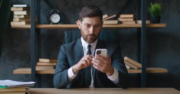 Απογοητευμένος Επιχειρηματίας Που Διαβάζει Άσχημα Νέα Smartphone Ενώ Κάθεται Στο — Αρχείο Βίντεο