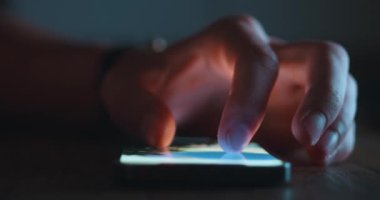 Yakın plan: erkek eli, gece evde masada akıllı telefon kullanıyor. Yüksek kalite 4k görüntü