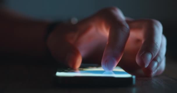 屋内のテーブルで夜にスマートフォンを使用して男性の手 高品質4K映像 — ストック動画