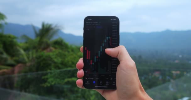 Close Crypto Enthusiast Holding Mobile Phone App Studying Graph Changes — Video