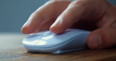Male student click white computer mouse and scroll internet websites studying online searching information on work desk. Close up of male hand using computer mouse to working at laptop computer.