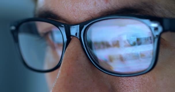 夜遅くに働く眼鏡の男性の目を閉じて自宅でラップトップコンピュータの前でインターネットページをスクロールします オンラインで動作するコンピュータ画面の反射を持つメガネの男性のマクロ肖像画 — ストック動画