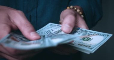 Close-up male hands counting money. Unrecognizable man calculating cash dollars indoors. Money profit concept. Person counts 100 dollar banknotes in hands, close up.