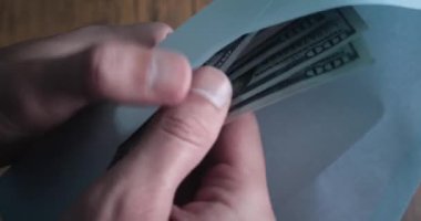 Person counting money cash from envelope closeup. Illegal business deal with cash money for tax evasion. Dirty money cash salary in envelope Closeup male hands counting 100 dollar bills from envelope