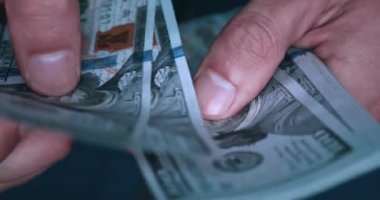 close-up male hands of a worker counting dollar bills salary for the work performed. Money salary concept. Man counting earned money close-up of hand.