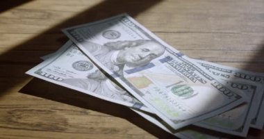 Close-up counting money. Person put dollars, bill by bill on the table counting money. Calculation of profit in American dollars banknotes. Payment of debts and loans.