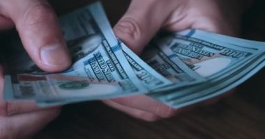 close-up male hands buyer counts money cash to pay for services or product. Male client counts 100 dollar bills to pay for a service. Money counting. Concept of a deal