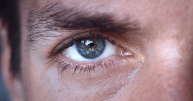 Erkek gözünün yakın çekimi. Erkek gri gözün makro görüntüsü yavaş çekimde kameraya bakıyor..