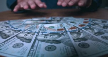 Male hands appropriate money cash lying on table. Close-up of businessman taking his earned cash dollar bills. Businessman rejoices in money profit. Concept of earning easy money. Thirst for profit.