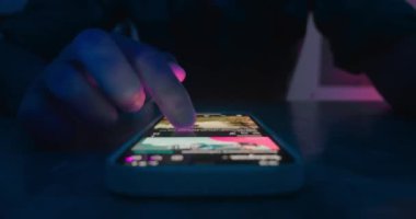 Geceleri erkek parmak kaydırma akıllı telefon ekranı sosyal ağlarını kapatın. Akıllı telefon, internet sayfaları, sosyal medya, zaman ayarlı akıllı telefon ekranı uygulaması. Akıllı telefon kullanma kavramı.