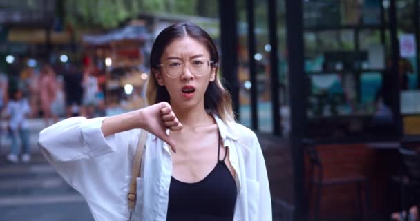 Portrait Young Asian Woman Glasses Thumb While Shopping Mall Frowning – Stock-video
