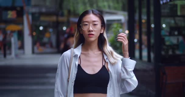 Genç Güzel Asyalı Kız Öğrenci Alışveriş Merkezindeki Kameraya Bakıyor Gözlüklü — Stok video
