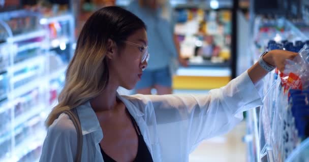 Aziatisch Vrouwtje Kiest Onderzoekt Het Product Schappen Van Supermarkt Huishoudelijke — Stockvideo