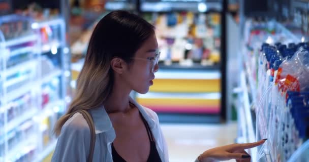 여자는 슈퍼마켓의 구역에서 샴푸를 아시아 여성은 마켓에서 제품을 합니다 매력적 — 비디오