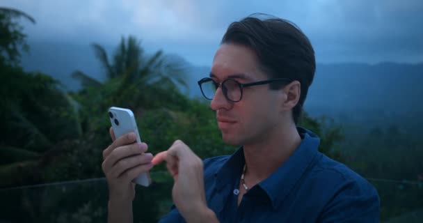 Портрет Молодого Чоловіка Років Окулярах Використовуючи Мобільний Телефон Ввечері Відкритому — стокове відео