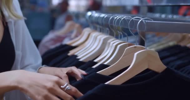 Blisko Kobiet Ręce Wybierają Modne Nowe Ubrania Butiku Zbliżenie Podczas — Wideo stockowe