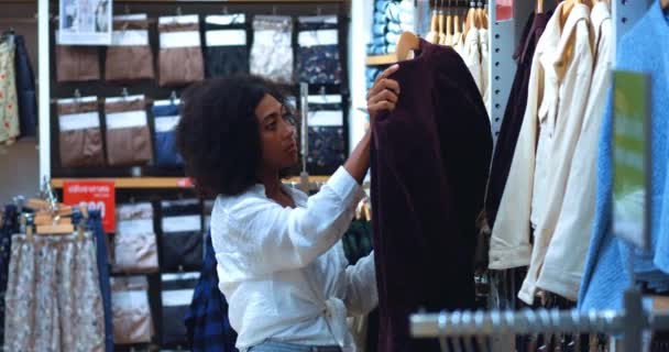 Pleasant Female Shopaholic Choosing Cute Shirt Jacket Inspecting Textile Quality — Vídeos de Stock