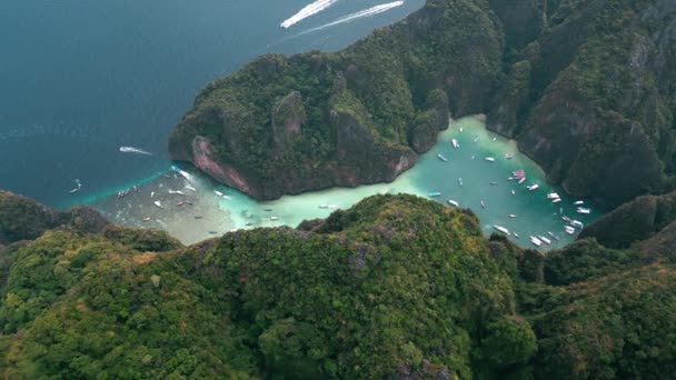 空中からの眺め象徴的な熱帯のターコイズブルーの水石灰岩の崖 ピピ島のタイに囲まれたピレラグーン タイの熱帯の島にボートでいっぱいの風光明媚なピレラグーンまたはピレベイ — ストック動画