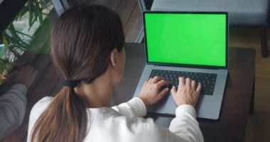 Yeşil ekran tuşlu dizüstü bilgisayar kullanan, krom tuşuna basan, mesaj yazan, kahve molasında laptopta çalışan serbest çalışan bir kadın..