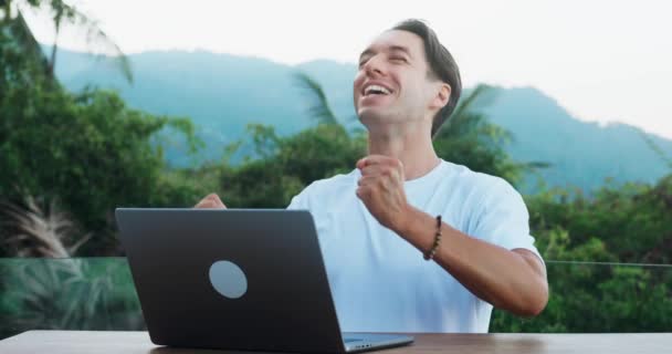 惊慌失措的商人看着手提电脑监视器 表现出了胜利的情感 兴奋的男性自由职业者对创业的突如其来的成功感到高兴 他们正在风景秀丽的户外电脑上努力工作 — 图库视频影像