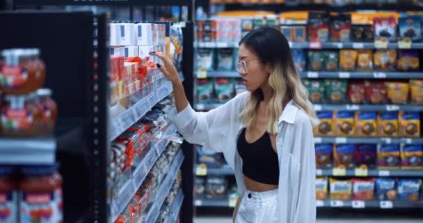 Csinos Fogyasztó Vizsgálja Élelmiszerárak Egy Élelmiszerboltban Miközben Vásárol Ázsiai Fiatal — Stock videók