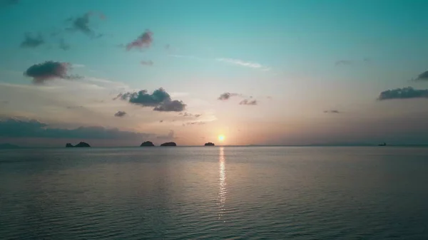 Denizde gün batımı, kamera ileri gidiyor. Deniz günbatımının sinematik videosu, güzel turkuaz su ve mavi akşam gökyüzü. Denizde tatil konseri. Hava görüntüsü.