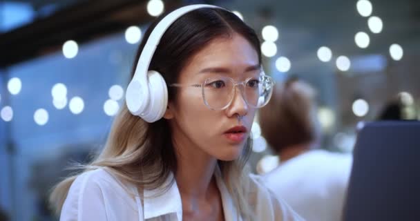 Fiatal Ázsiai Üzleti Projektmenedzser Fülhallgatókban Laptop Számítógépen Dolgozik Forgalmas Modern — Stock videók