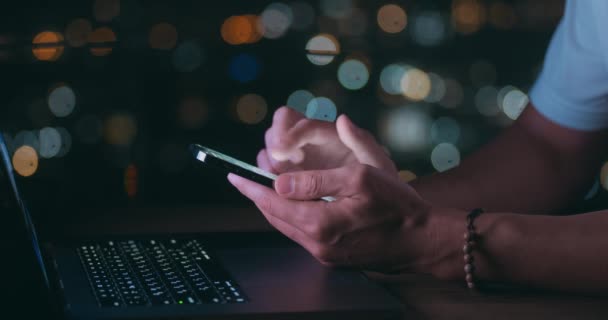 Rolagem Manual Masculina Navegando Smartphone Durante Noite Enquanto Trabalhava Laptop — Vídeo de Stock