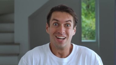 Hevesli bir adam zaferi kutluyor, ellerini yumruk yapıp sevinçten havalara uçuyor, arka planda 