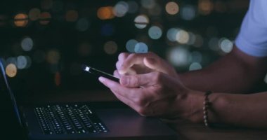 Mans bilgisayarda çalışırken gece akıllı telefonlarda el gezintisi yapıyor. Akıllı telefon kullanan, sosyal ağda gezinen biri. Erkek el, akıllı telefonundaki uygulamayla haber kaynaklarını tarıyor..