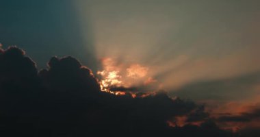 Güzel bir zaman atlaması, güneş ışınları gökyüzündeki kara fırtına bulutlarında parlıyor. Gökyüzünün sinematik videosu, güneş büyük bulutların arkasından dışarı bakar ve akşam veya sabah gökyüzünü aydınlatır. Umut kavramı