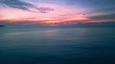 Renkli pembe deniz manzaralı gün batımı ya da deniz yüzeyinden gün doğumu, hava manzaralı. Sinematik görkemli pembe günbatımı ya da ufukta sakin deniz suyuyla gündoğumu gökyüzü renkleri. Yaz ve seyahat tatil konsepti.