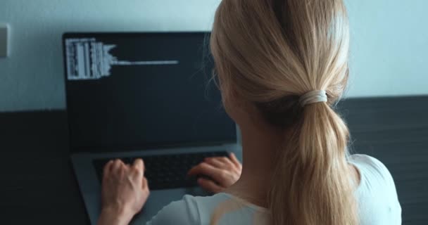 女性プログラマーの開発者の背面ビューは 職場に座ってコンピュータモニタとプログラムコードを書くことを見て Itソフトウェア開発者がラップトップコンピュータでデータコーディングプログラミングを入力 — ストック動画