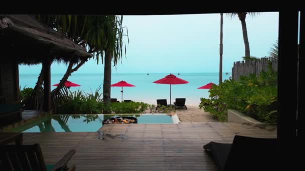 豪华酒店有一个可以俯瞰大海的私人游泳池 奢华的暑假概念 从带有私人海滩的酒店房间 到热带度假胜地度过一个昂贵的暑假的红色雨伞 — 图库视频影像