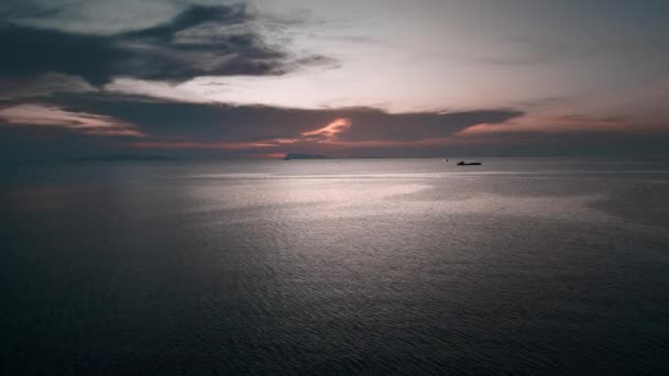 空の映像 無人機はオレンジ色の夕日に向かって海を飛びます 空には雲があり その後ろには日没時に太陽が隠されています 自然景勝地 旅のコンセプト — ストック動画