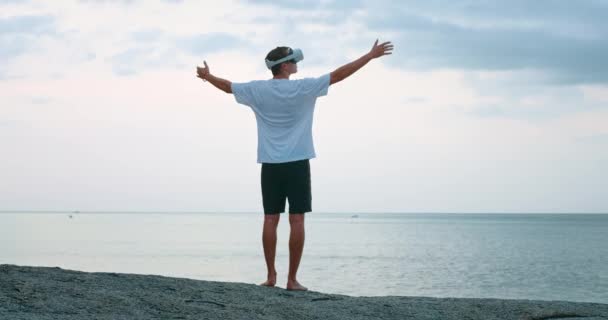Anak Muda Berkacamata Virtual Reality Saat Matahari Terbenam Mengangkat Tangannya — Stok Video