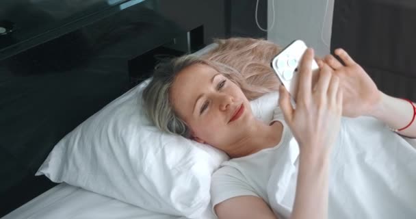 Vrouw Gebruikt Een Smartphone Terwijl Het Bed Slaapkamer Ligt Jonge — Stockvideo