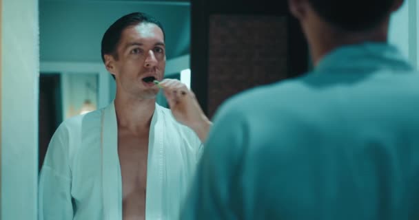 Spiegelung Spiegel Junger Mann Bademantel Zähne Putzen Mit Zahnbürste Modernen — Stockvideo