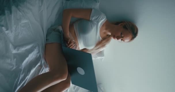 여성의 침대에 노트북을 사용하고 있습니다 노트북을 원격으로 만지고 집에서 컨셉의 — 비디오
