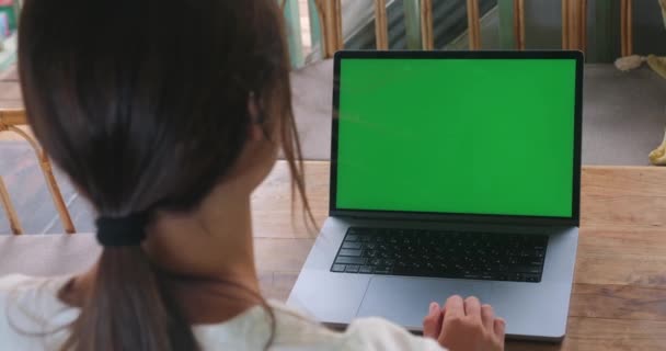 カフェに座っている間 緑の画面のラップトップを使用して若い女性 コーヒーショップで働く若いビジネス女性緑のモックアップ画面とラップトップコンピュータ上で動作します クロマキー コピースペース — ストック動画