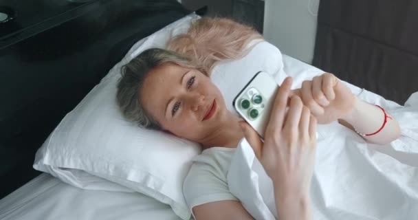 Тисячолітня Жінка Використовуючи Мобільний Телефон Лежить Ліжку Спальні Вранці Жінка — стокове відео