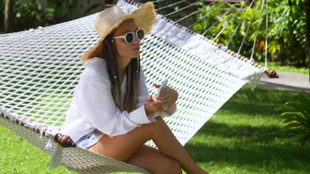 Upset Woman Straw Hat Sitting Hammock Summer Resort Holding Smartphone — Stock Video