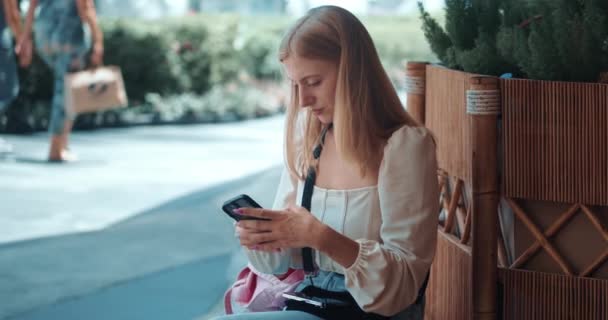 Młoda Kobieta Siedzi Ławce Parku Miejskim Używa Smartfona Wpisując Wiadomość — Wideo stockowe