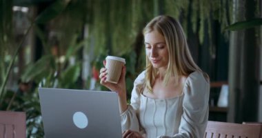 Bilgisayarda yazı yazan çekici sarışın menajer kadın serbest yazar. Kendine güveni tam bir kadın elinde kahve tutuyor ve bilgisayar hayatı konsepti üzerinde çalışıyor..
