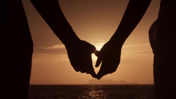 手を伸ばす男のクローズアップシルエットと女性が手を取る 相互理解 サポートの概念 ロマンチックなカップルは日没または夜明けの日に互いに手を取ります — ストック動画