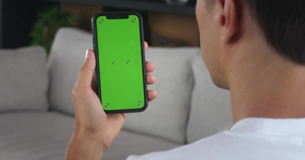 Mężczyzna Trzymać Telefon Komórkowy Dłoni Chroma Key Zielony Ekran Salonie — Wideo stockowe